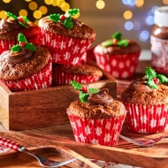 Krásně nazdobené mrkvové muffiny podávané na vkusném dřevěném tácu.