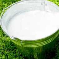 Schüssel mit Milch als Zutatenabbildung für Nutella, Nahaufnahme auf hellem Hintergrund.