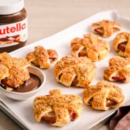 Gebackene Apfelringe mit Blätterteig auf Backblech, serviert mit nutella® als Dip		