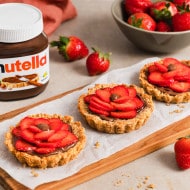 Bereinigtes Nutella Werbefoto: Glas mit Löffel und Haselnussgarnitur.