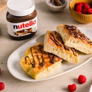 Airfryer-Focaccia mit Nutella-Glasur, goldbraun gebacken und auf Holzbrett serviert.