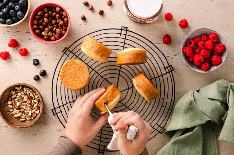 Gebackene New York Rolls mit Nutella werden auf einem Abkühlgitter dekoriert und mit gehackten Haselnüssen verfeinert.