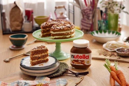 Karotten-Pekannuss-Kuchen mit Nutella-Swirl und Karamellglasur auf Kuchenplatte.