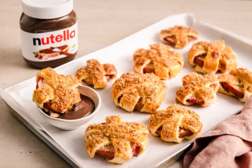 Gebackene Apfelringe mit Blätterteig auf Backblech, serviert mit nutella® als Dip		