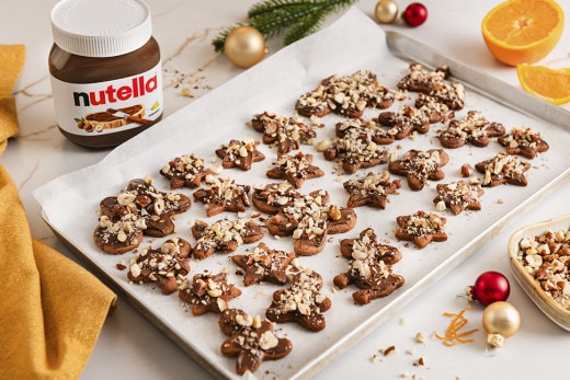 Dunkle Lebkuchen-Kekse gefüllt mit Nutella, bestäubt mit Puderzucker und Gewürzen.