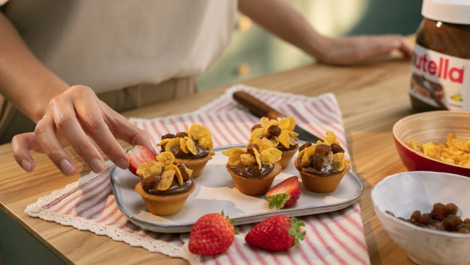 Traditionelles Kababayan-Gebäck serviert mit Nutella-Topping und frischen Früchten auf Teller.
