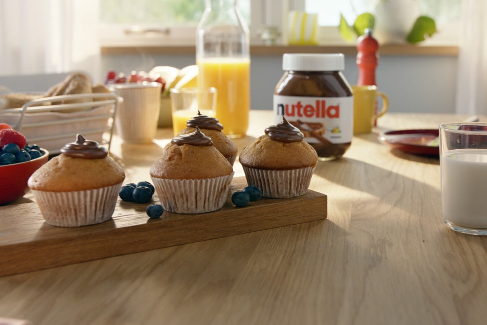 Muffins mit Nutella-Kern, goldbraune Oberfläche und Streusel auf Teller.