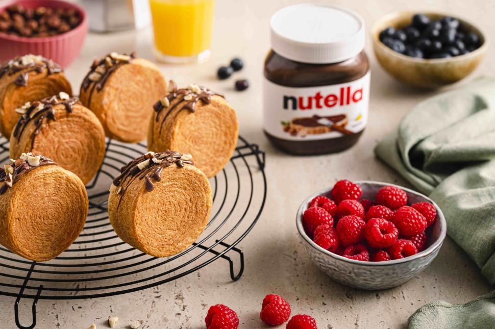 Servierte New York Rolls mit Nutella auf einem Gitter, begleitet von frischen Beeren und Nutella.
