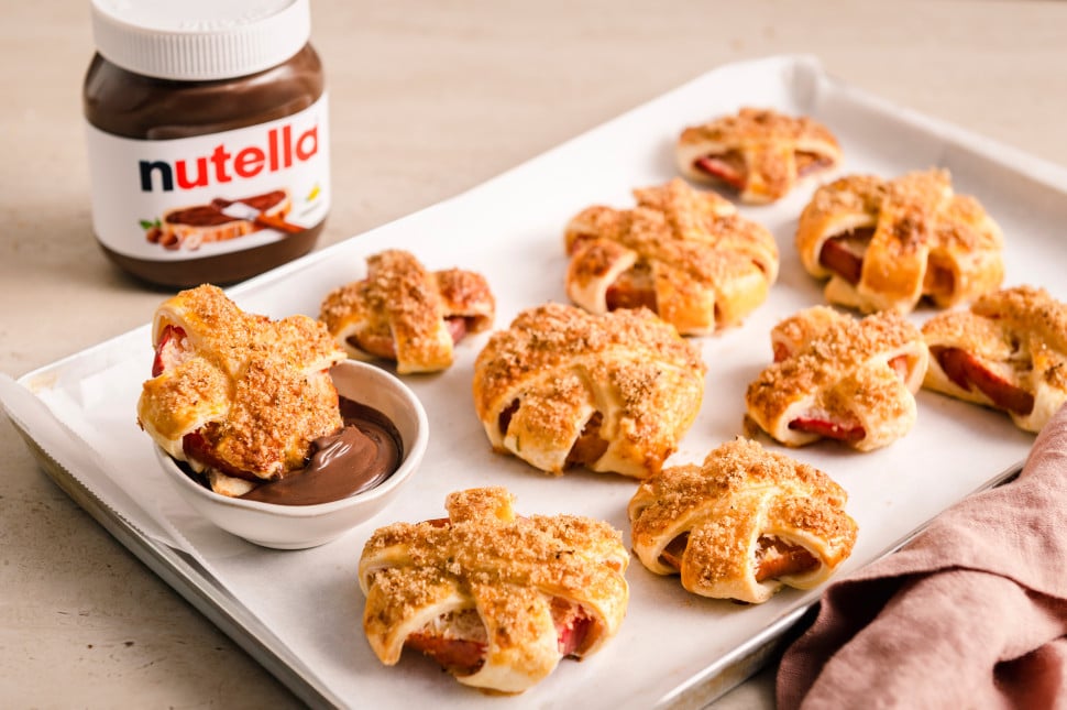 Gebackene Apfelringe mit Blätterteig auf Backblech, serviert mit nutella® als Dip