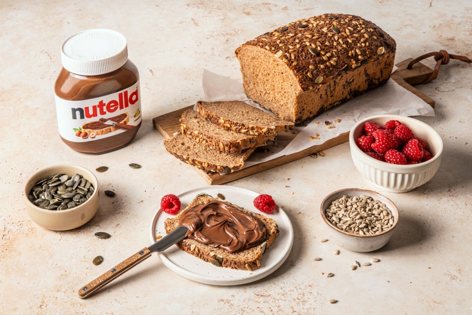 Nahaufnahme: Nutella-Glas mit Löffel und glänzender, schokoladiger Aufstrichschicht.
