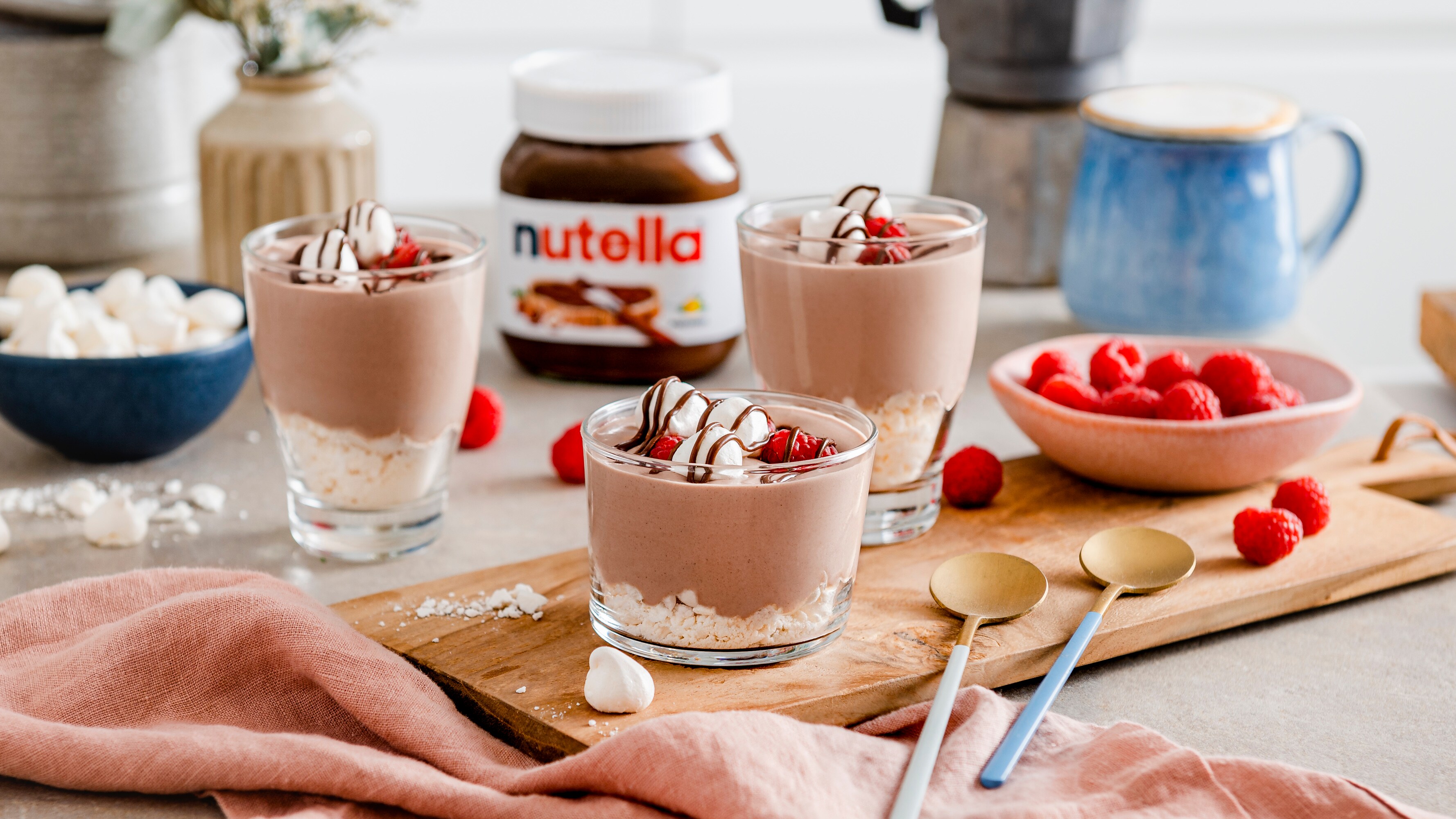 Leichte Nutella-Mousse in Gläsern, dekoriert mit Kakaopulver und Schokoraspeln.