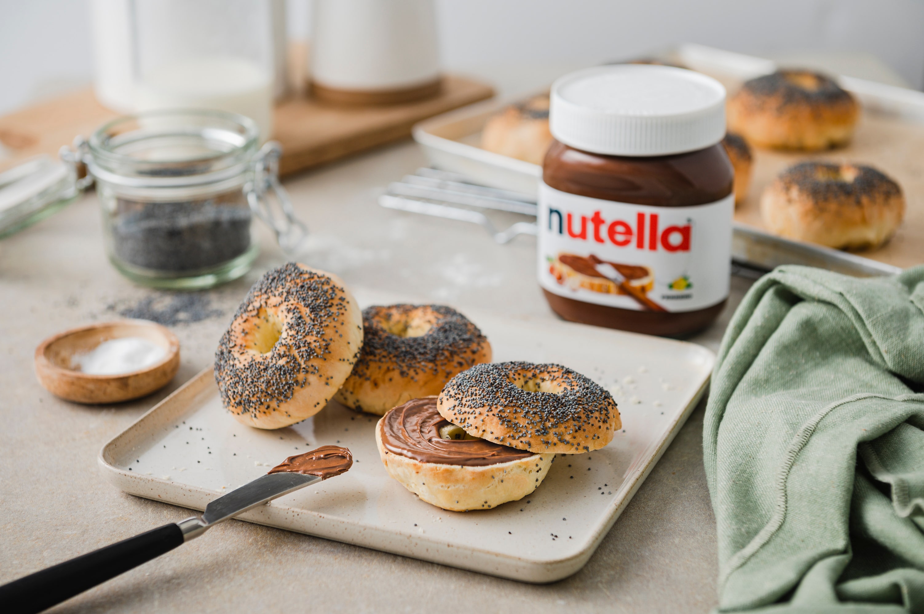 Stadt-Lifestyle: Nutella-Glas neben Croissant auf Café-Tisch, urbanes Frühstücksbild.