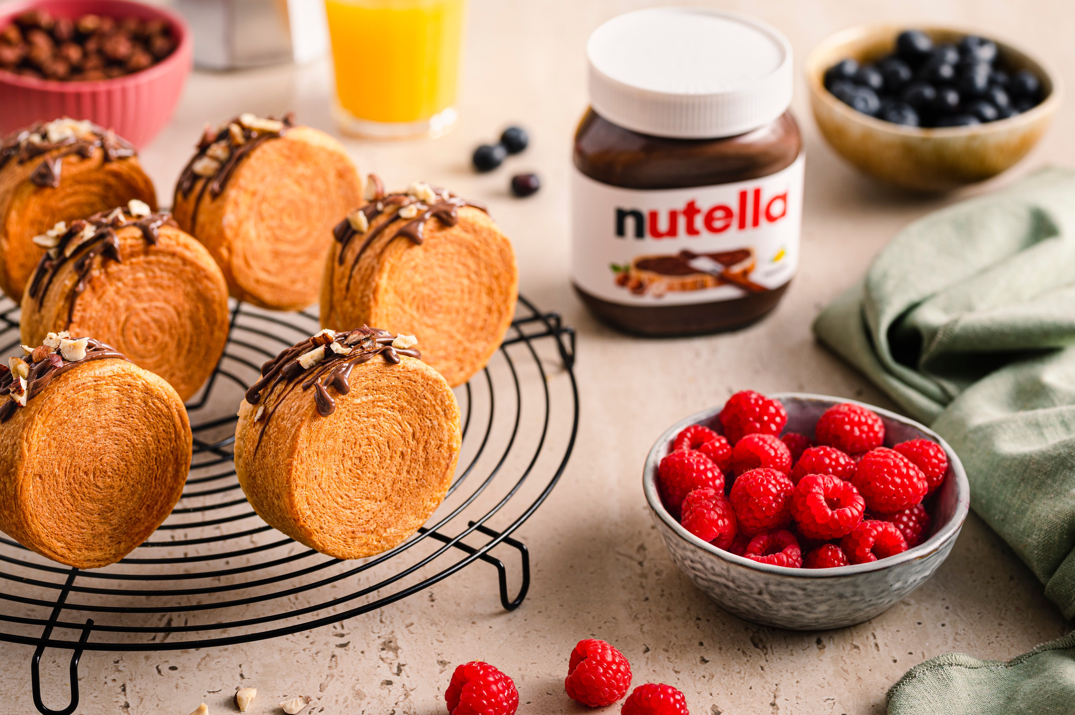 Nutella-Glas neben frisch gebackenem Brot auf rustikalem Holzbrett, serviert.