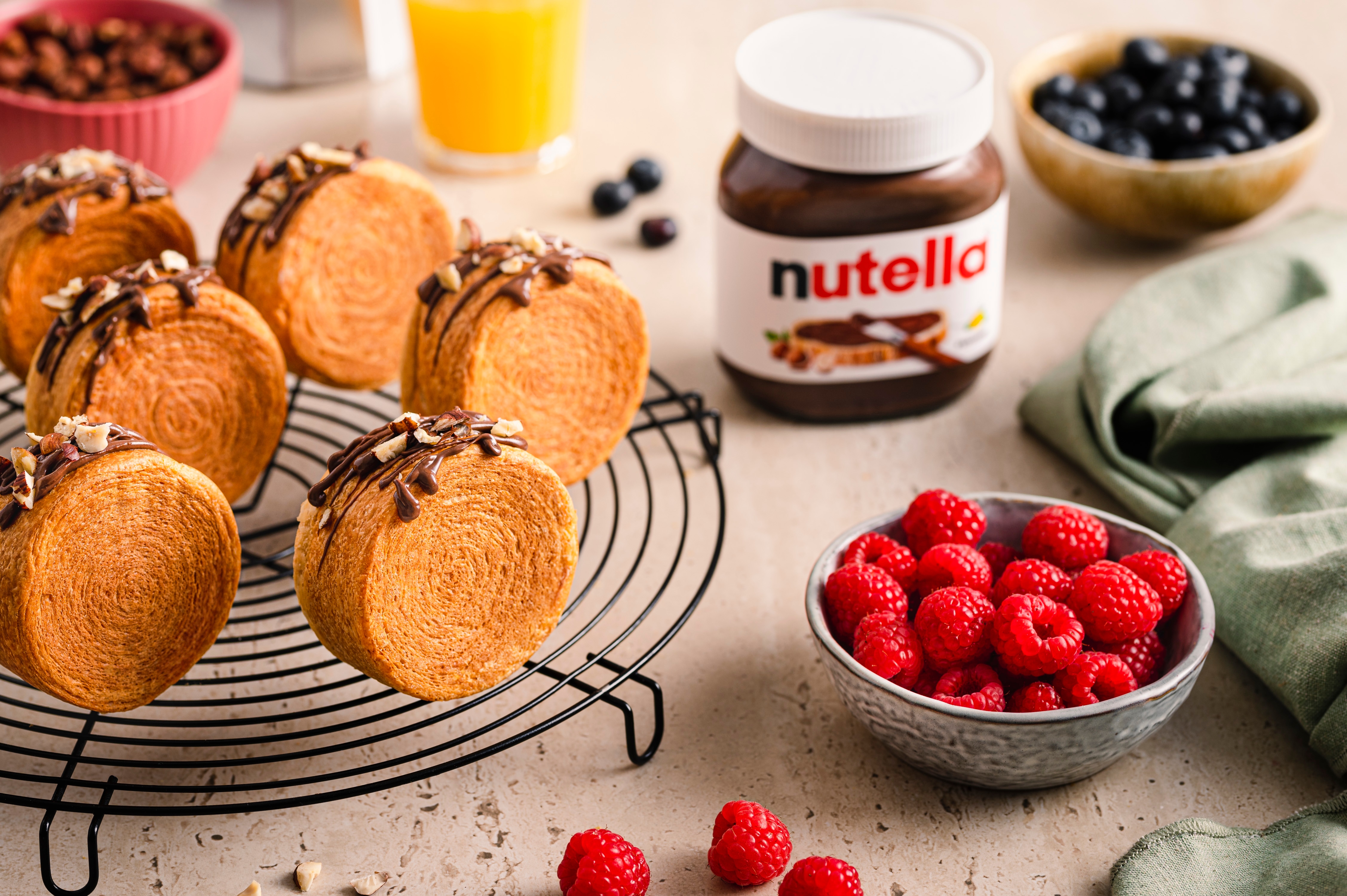 Nutella-Glas neben frisch gebackenem Brot auf rustikalem Holzbrett, serviert.
