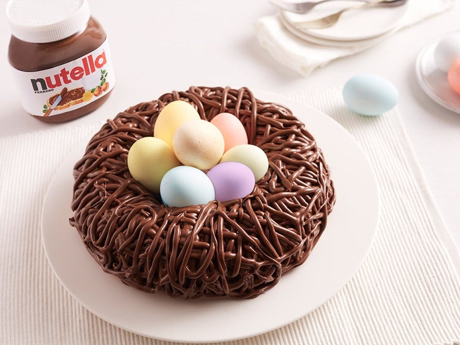 Nid de Pâques chocolaté garni de Nutella et petits œufs.