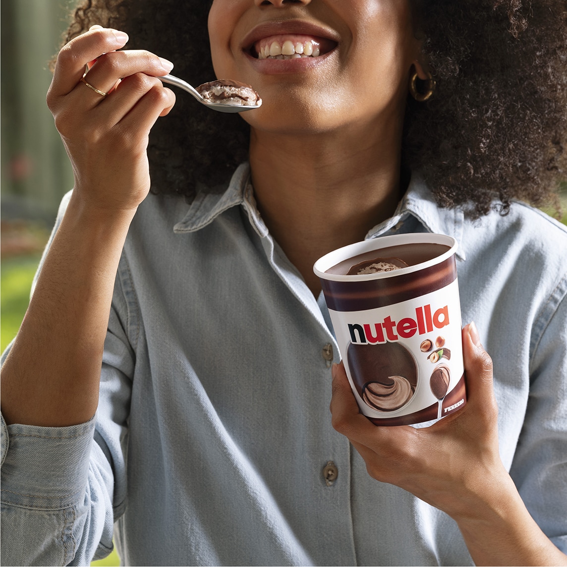 Pot de Nutella ouvert accompagné de glace à la cuillère, décor commercial.
