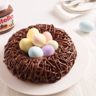 Nid de Pâques chocolaté garni de Nutella et petits œufs.
