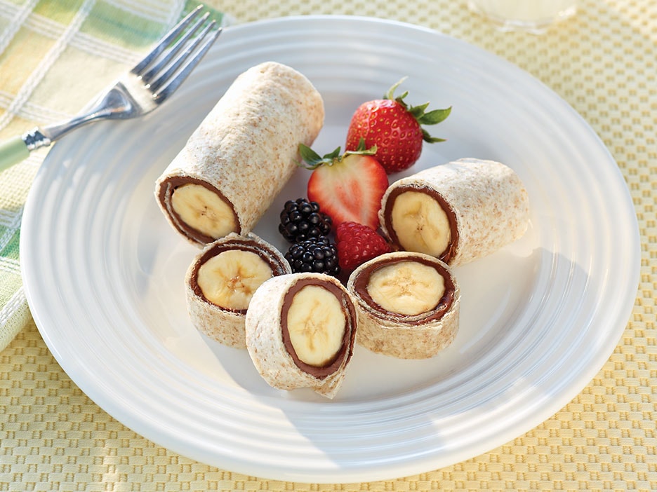 Whole-grain breakfast roll-up filled with Nutella and sliced strawberries.
