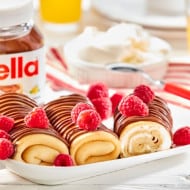 Chocolate Nutella barfi squares garnished with chopped pistachios on plate.