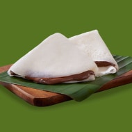 Neer dosa crepe folded and spread with Nutella, served with banana slices.