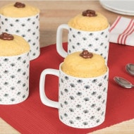 Four mug cakes in are displayed on a red place mat with a dollop of Nutella® in the centre of the cake.