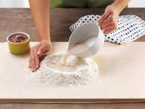 Sliced brioche preparation step showing Nutella being spread on slices.