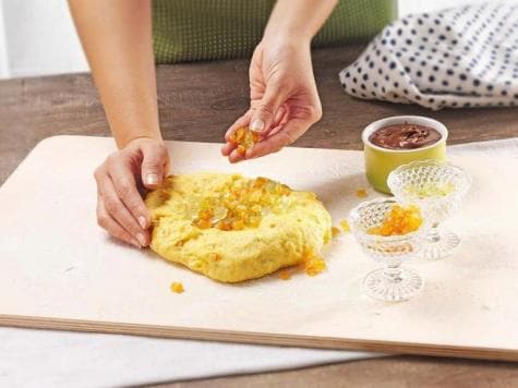 Gluten-free orange sponge cake topped with Nutella and festive decorations.