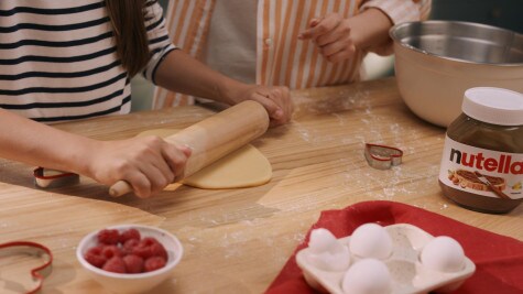 Heart-shaped cookies filled with Nutella arranged neatly on tray.