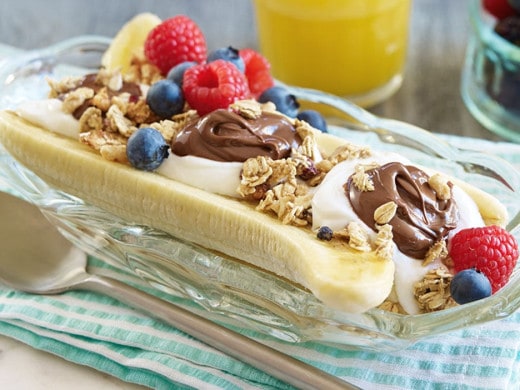 Banana split breakfast bowl topped with Nutella and fresh fruit.