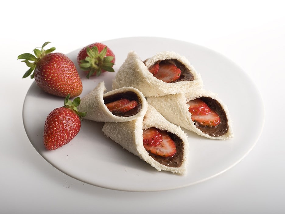 Strawberry and Nutella wraps rolled and sliced, served on plate.