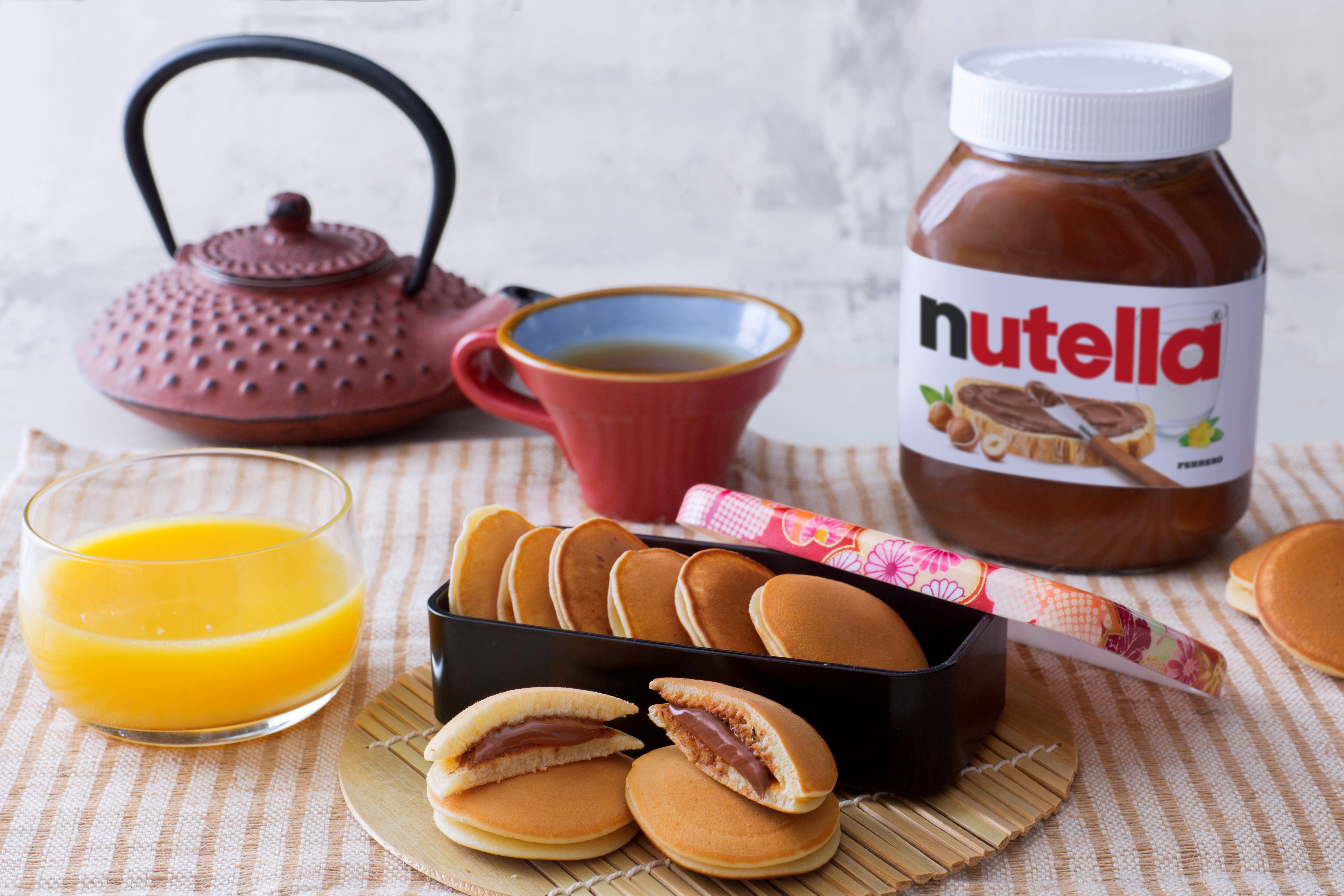Mini dorayaki giapponesi farciti con Nutella, impilati su piatto.
