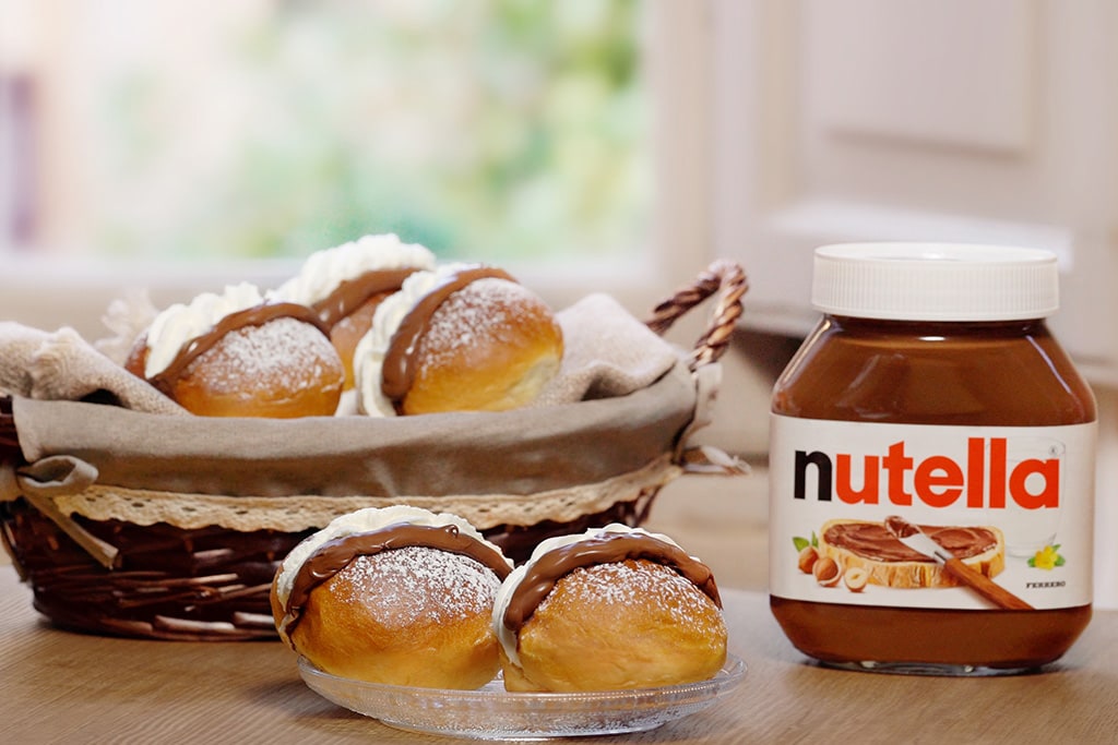 Maritozzo morbido farcito con Nutella e panna su piatto.