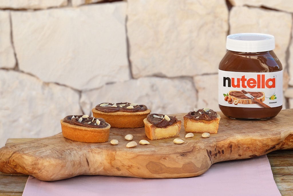 Pasticciotto leccese ripieno di crema e Nutella su tavola.