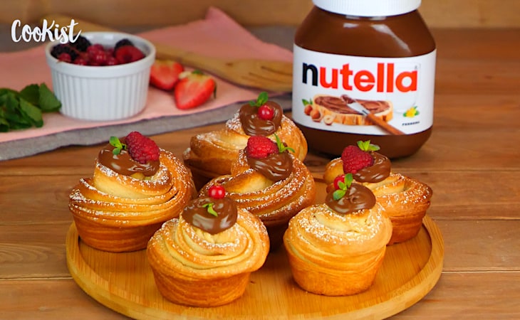 Cruffin con Nutella, croissant-torta, glassa leggera su piatto.