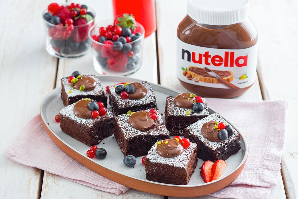 Quadrotti dolci al cioccolato ripieni di Nutella, tagliati a cubetti.