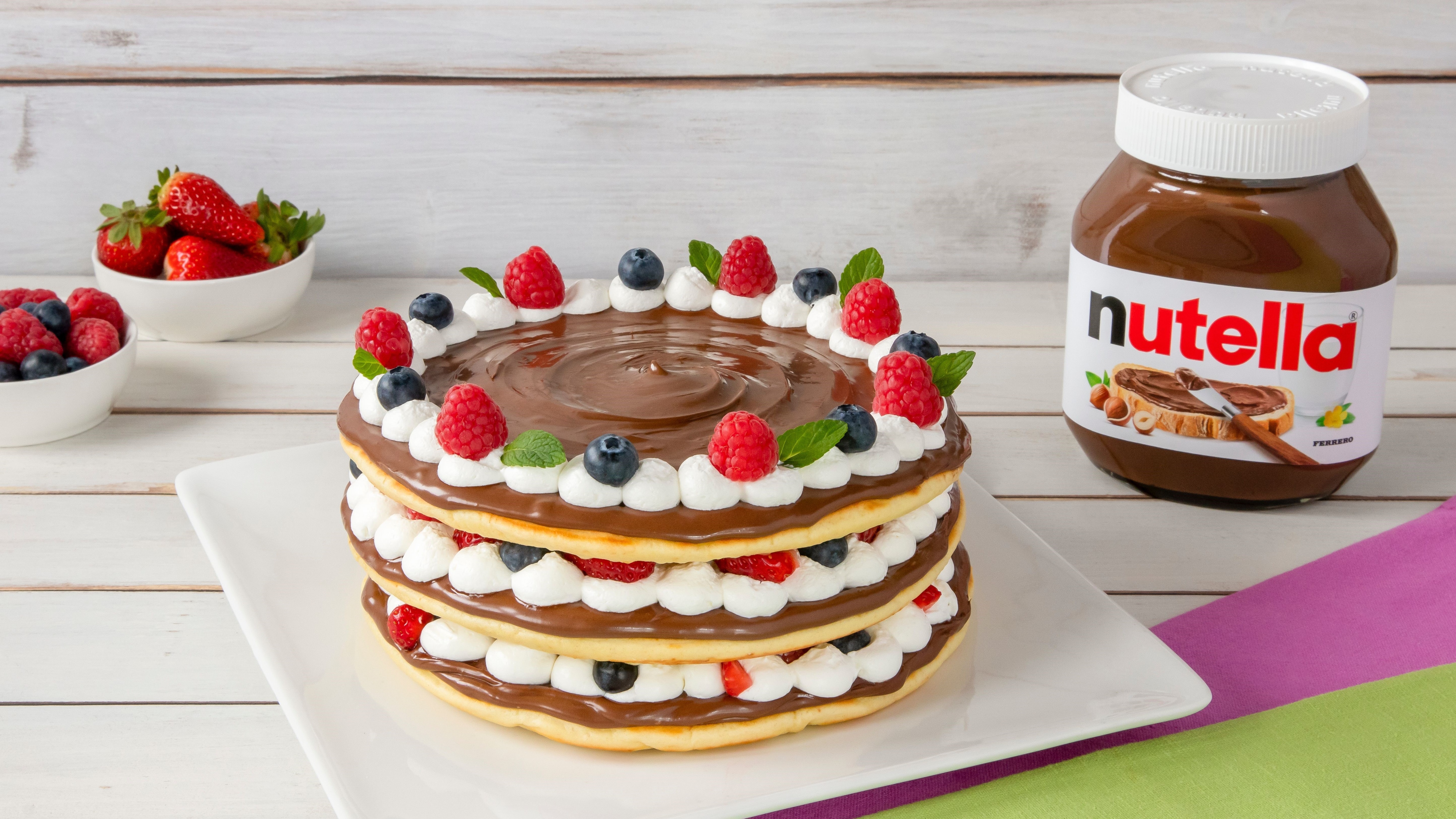 Torta fatta con pancake impilati e farcitura di Nutella.