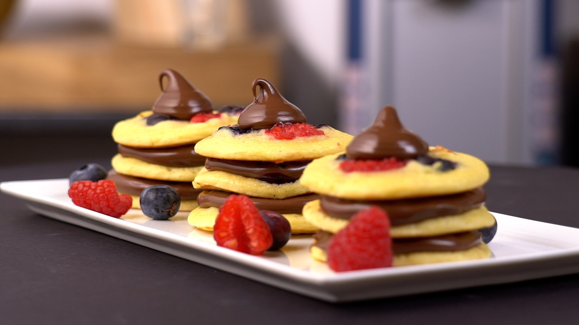 Pancake bites con Nutella serviti su spiedini o piattini.