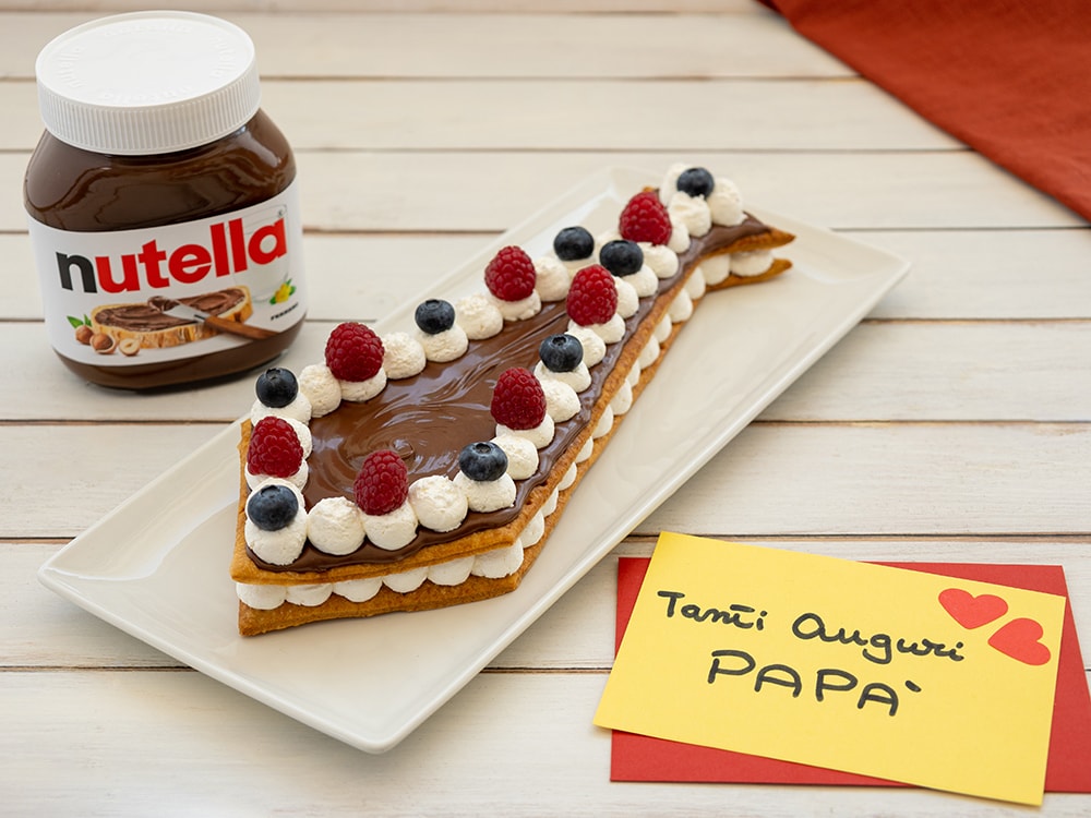 Cravatta dolce di sfoglia arrotolata con Nutella, tagliata a fette.