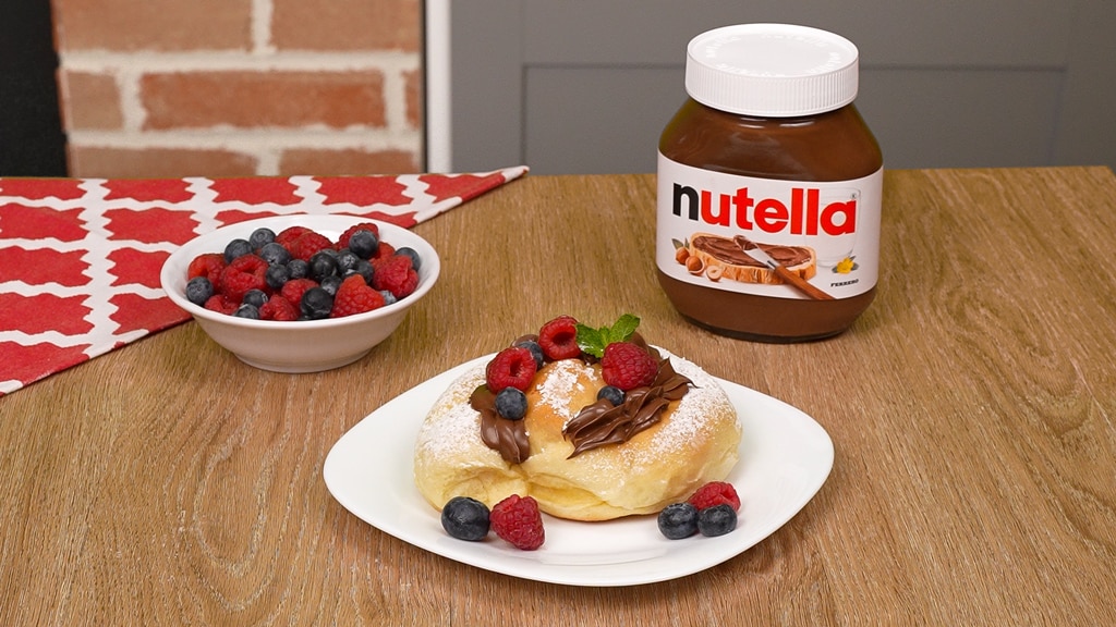 Ensaimada farcita con Nutella, spolverata di zucchero e cannella.