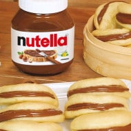 Bao buns ripieni di Nutella serviti su piatto bianco.