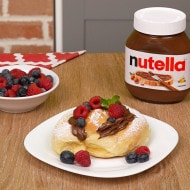 Ensaimada farcita con Nutella, spolverata di zucchero e cannella.