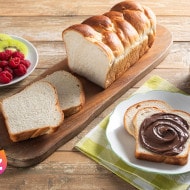 Fetta di crostata al cioccolato con striature di Nutella e nocciole.