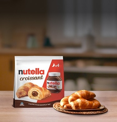 Croissant appena sfornato farcito con Nutella, doratura uniforme e cuore cremoso.