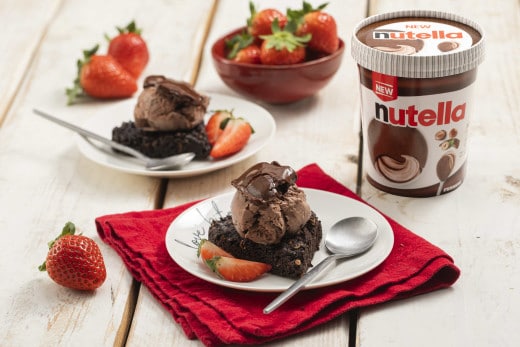 Coppetta di gelato alla Nutella, decorata con nocciole tostate.