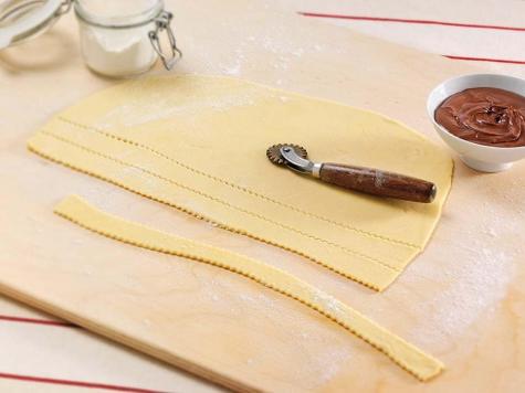 Frying cartellate dough strips before folding and filling with Nutella, step two.