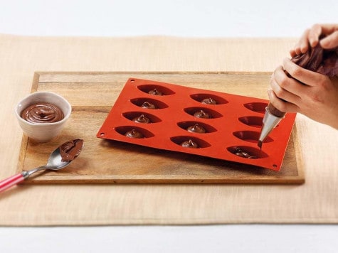 Filling pastry discs with Nutella and shaping karanji, recipe step one.