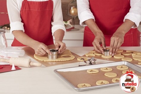 Assembling and dusting cut-out Nutella sandwich cookies, recipe step four.