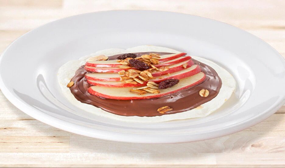 Mini pizzeta de manzana con Nutella y canela, servida caliente.