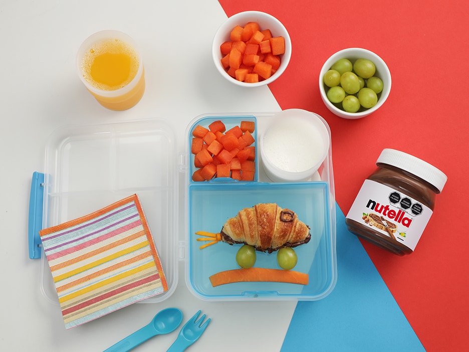 Carrito de desayuno con frascos de Nutella y accesorios sobre mesa.
