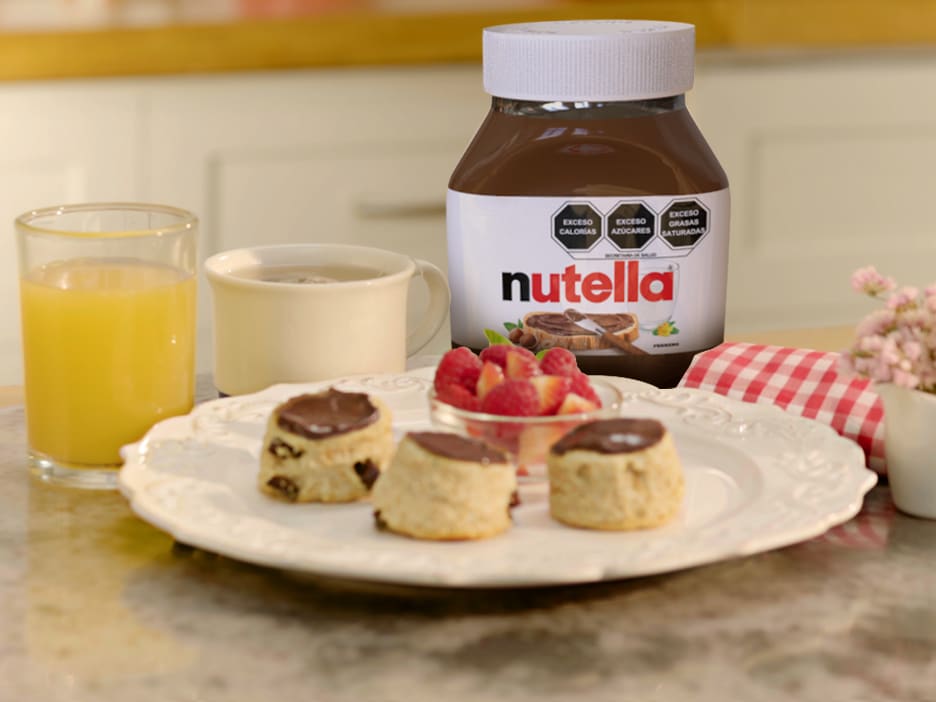 Pastel estilo inglés con Nutella y crema, servido en vajilla clásica.